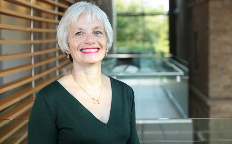 headshot of Dr. Dorothy Kessler smiling at the camera and wearing a green blouse. Her grey hair is cut short to the chin and she is standing in front of an out of focus office background.