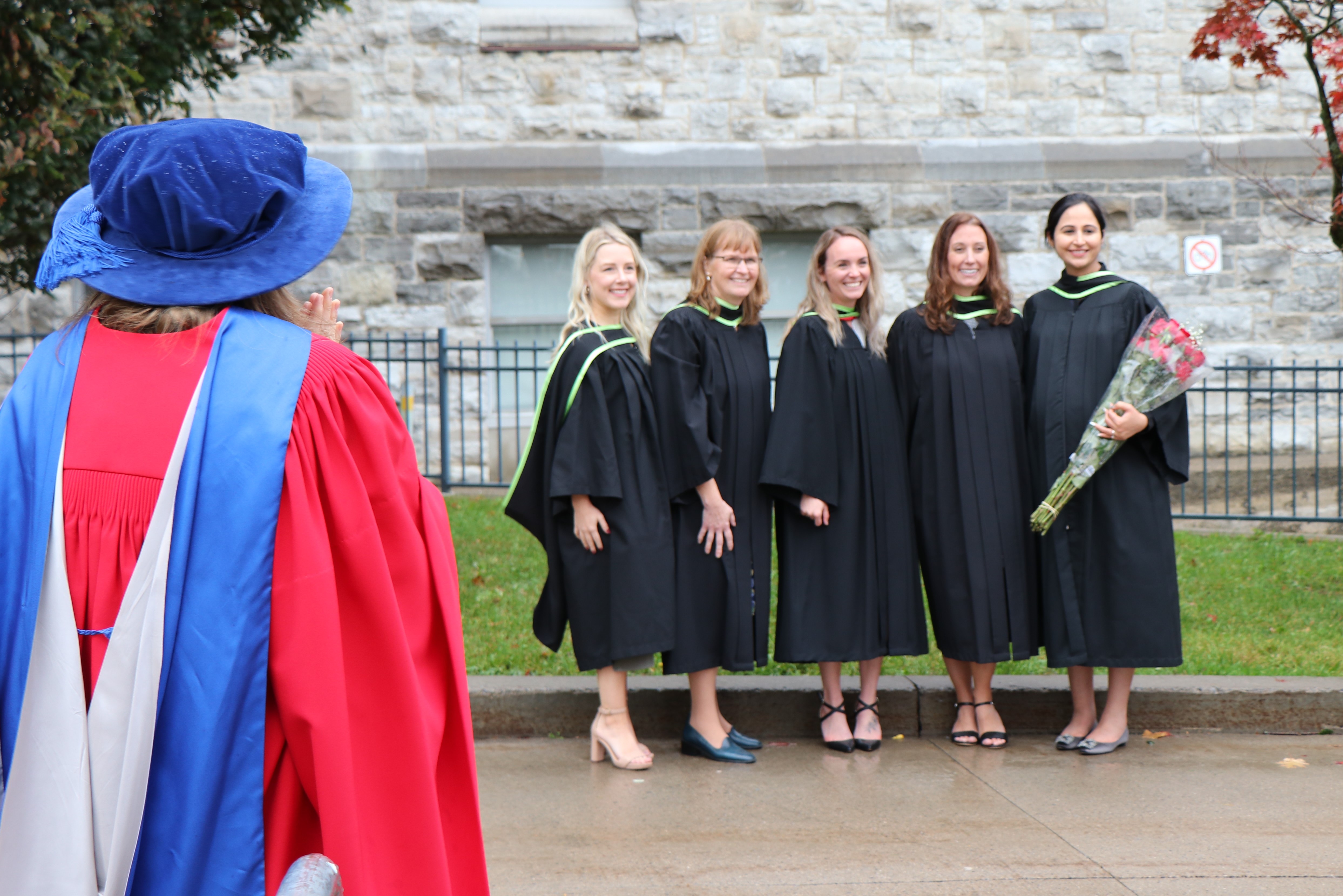 
                         How to Apply to MHPE                                                    - 
                          Dr. Stockley looking on as graduates pose for photos in 2022.                                                    