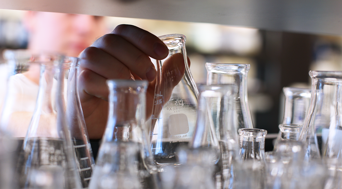 A research lab showing someone reaching for a beaker