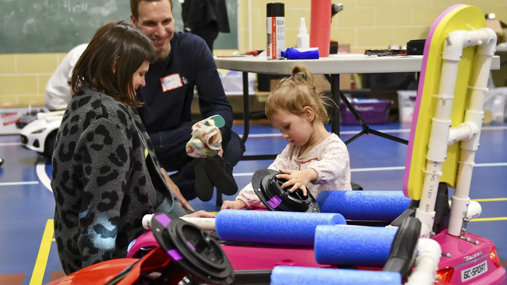 A family checks out one of the toy electric cars 