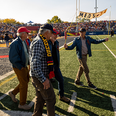 Alumni on the football field during homecoming