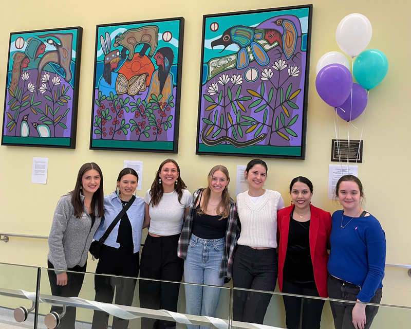 Students under the 3 new paintings in the School of Medicine