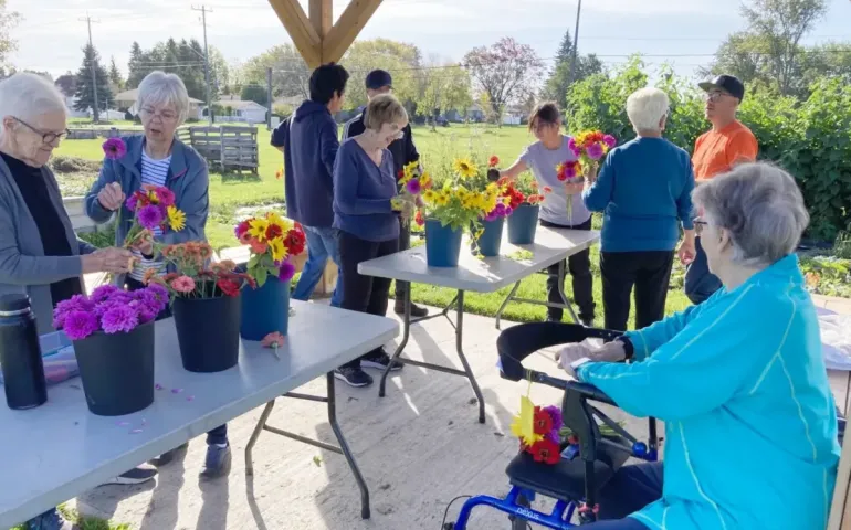 Oasis members of the community in Thunder Bay participate in a flower arranging workshop outside