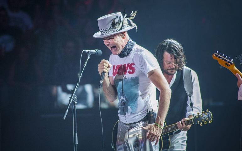 Tragically Hip singer Gord Downie wearing a Jaws t-shirt and silver hat sings during the band's final concert