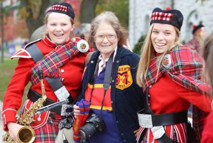Dr. Pamela Frid at alumni event with two female members of the Queen's band on either side of her 