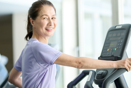woman on treadmill looking over her shoulder and smiling