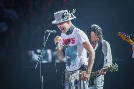 Tragically Hip singer Gord Downie wearing a Jaws t-shirt and silver hat sings during the band's final concert